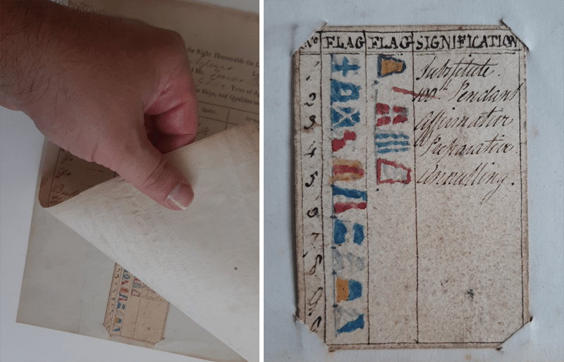 Folded mariner's certificate next to a hand-drawn table of signal flags